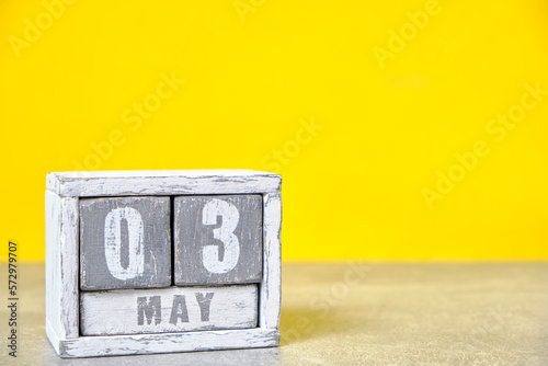 May 3, Wooden desktop calendar yellow background.Spring month depicted on cubes.Place for your ideas.World Press Freedom Day.
