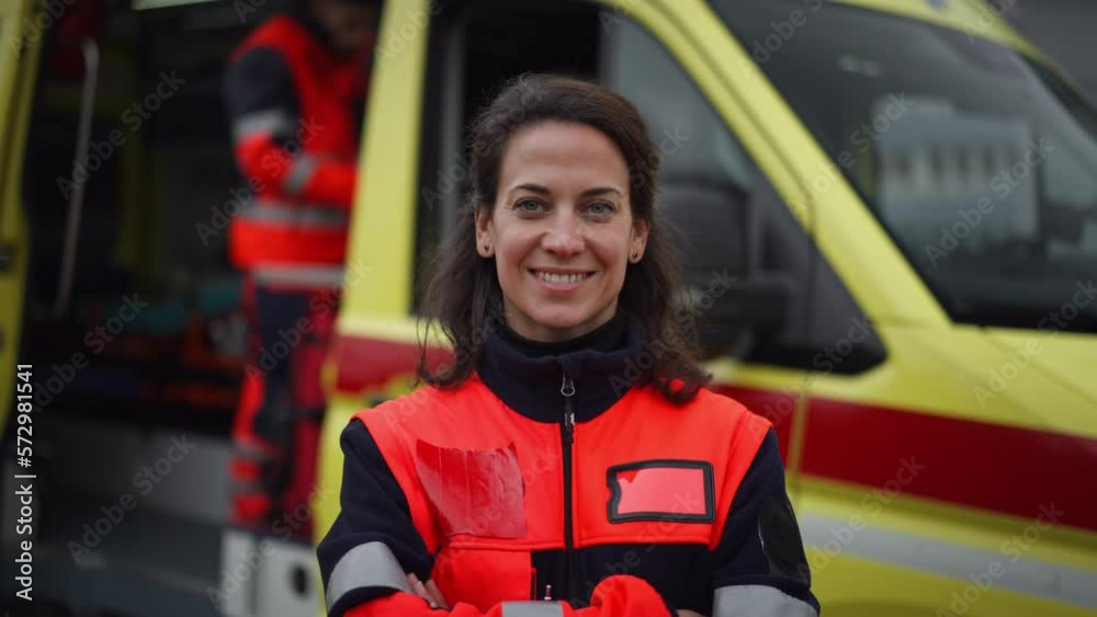Young woman doctor standing in front of ambulance car. Young woman doctor standing in front of ambulance car.