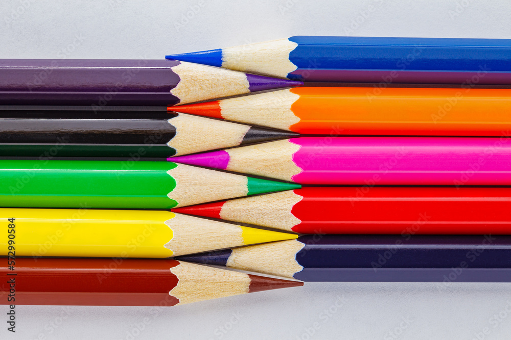 Colored pencils, sharpened, lie towards each other on white background Colored pencils, sharpened, lie towards each other on white background