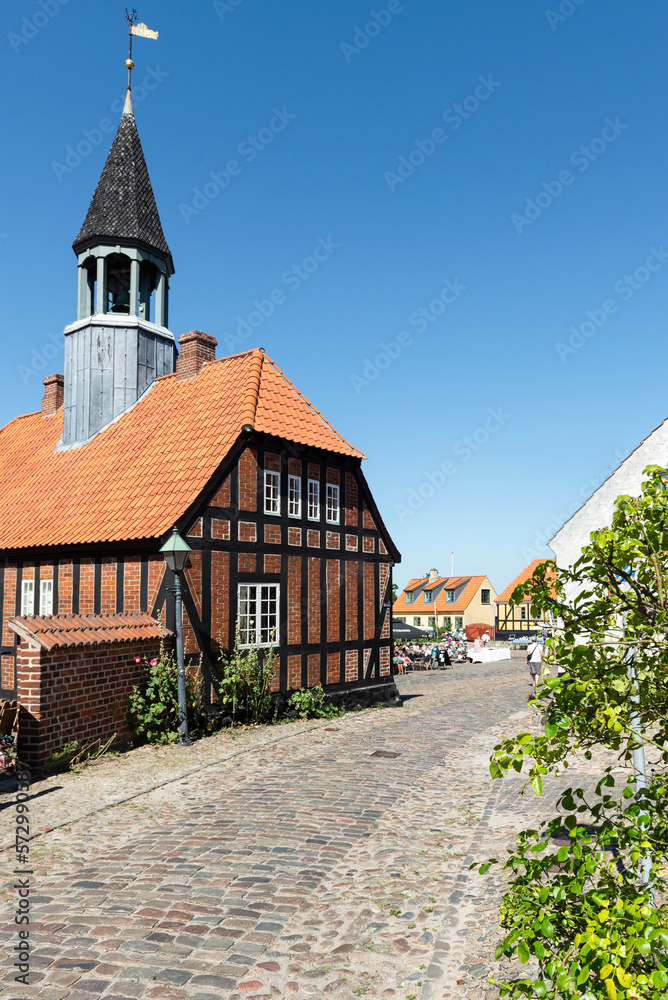 Das alte Rathaus von Ebeltoft, Djursland, Dänemark aus Fachwerk, rotem Backstein und mit Turm in der Sonne vor blauem Himmel