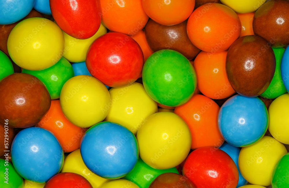 Multi-colored round and oval candies in bulk full depth of field background wallpaper, uniform texture pattern Multi-colored round and oval candies in bulk full depth of field background wallpaper, uniform texture pattern