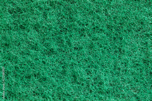 Fleecy fibrous synthetic green surface sponge close-up macro background wallpaper, uniform texture pattern