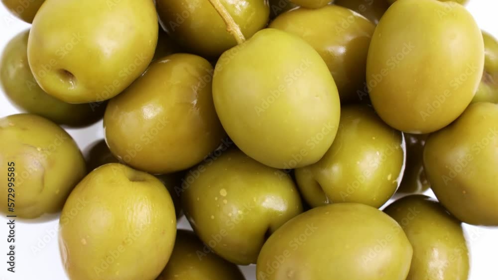 Top view of many green marinated whole olives circle rotation close up Top view of many green marinated whole olives circle rotation close up