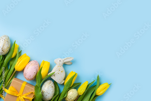Photography Modern background for Easter holiday with easter golden eggs, gift box and yellow  tulip flowers