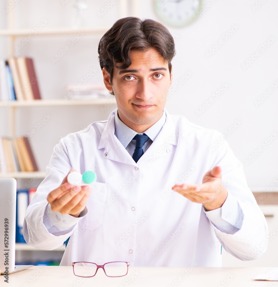 Young handsome doctor oculist working at the clinic Young handsome doctor oculist working at the clinic