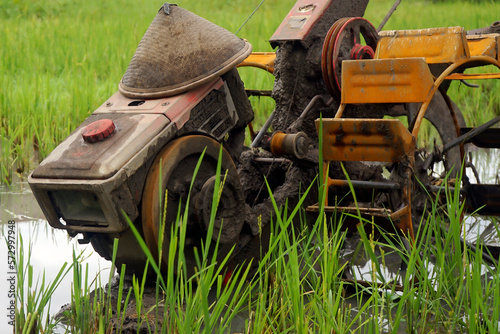 dirty looking ploughing tractor full of mud and rusty wheels photo
