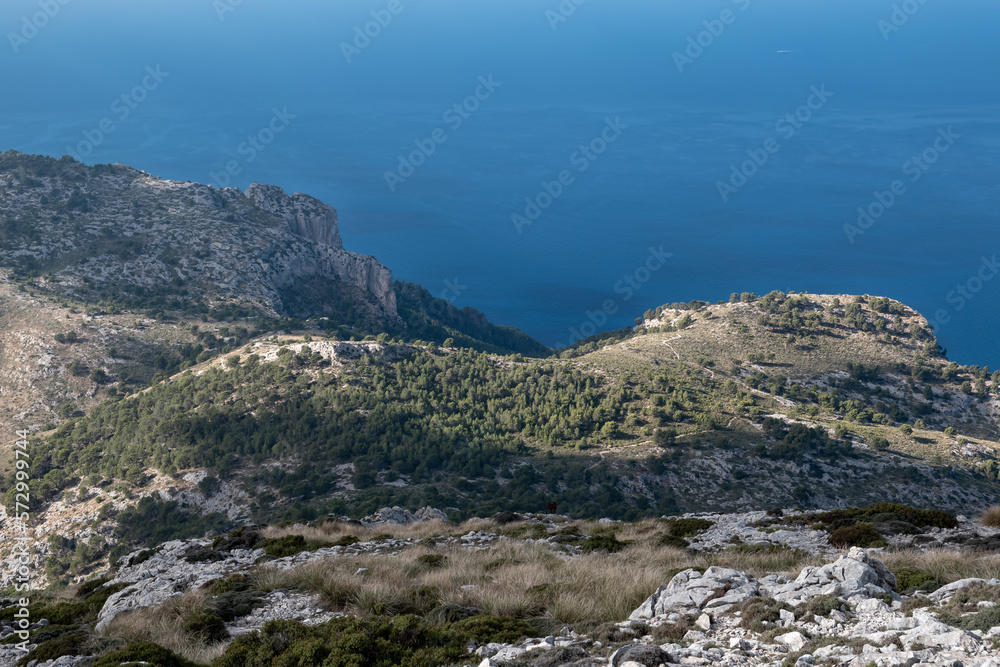 Contrast between blue from the sea and green and grey from the mountains Contrast between blue from the sea and green and grey from the mountains