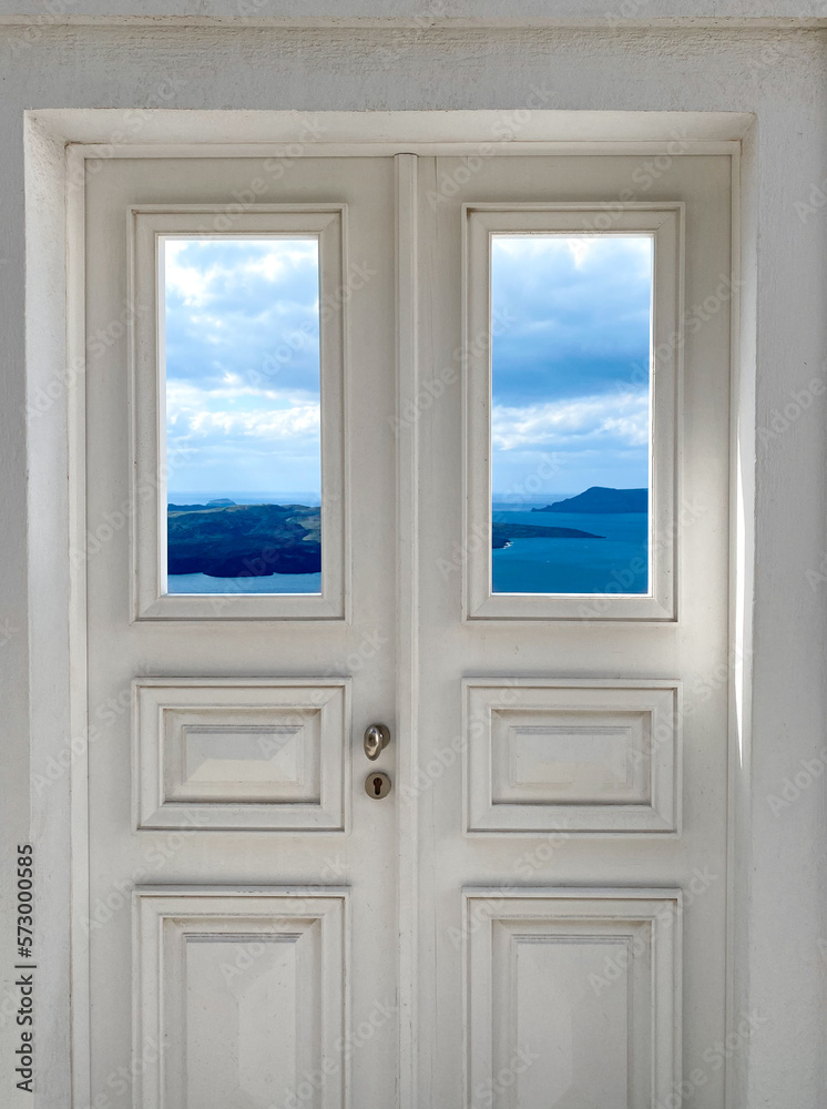 Fototapeta premium Traditional greek, beautiful brown wooden door above aegean sea Caldera on Santorini island, Greece. View to the sea through door, from Santorini