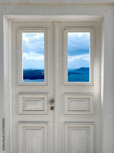 Traditional greek  beautiful brown wooden door above aegean sea Caldera on Santorini island  Greece. View to the sea through door  from Santorini