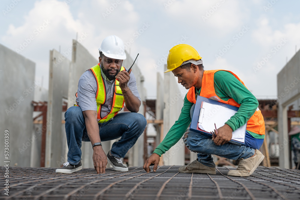 Foreman and laborer checking steel reinforcement cage for making