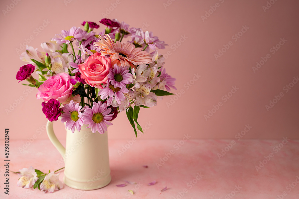 Beautiful fresh spring flowers. Pink bouquet of flowers in vase, on pink background. Copy space