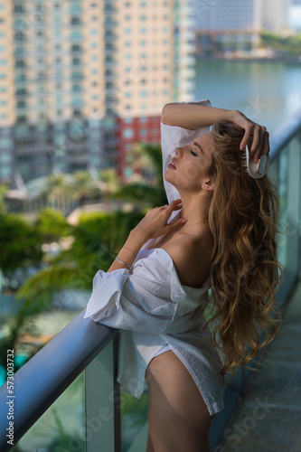 Beautiful woman with brush combing hair. Beauty girl with straight hair isolated on balcony terrace. Woman hold hairbrush near face. Healthy hair. Hairstyle and hair care concept. Morning hairs care. © Volodymyr