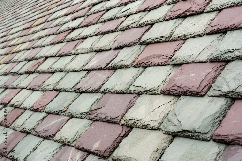 Slate roofing tiles on a historic building. Attractive, durable roofing material. Slate roofing tiles on a historic building. Attractive, durable roofing material.