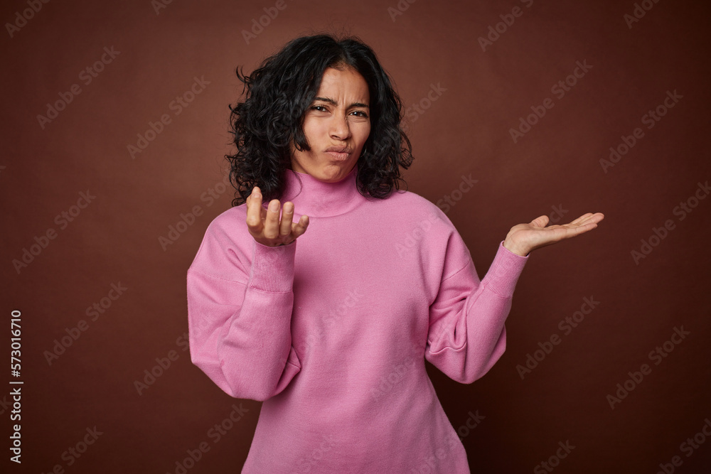 Young colombian curly hair woman isolated on brown background showing that she has no money. Young colombian curly hair woman isolated on brown background showing that she has no money.