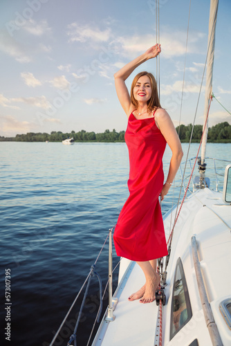 Beautiful woman relaxing on the nose of the yacht at a sunny summer day at the river and enjoying at happy holidays © svittlana