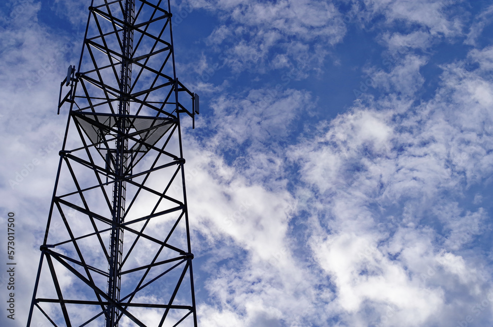 Wieża telefoni komórkowej na tle błękitnego nieba z chmurami. Wieża telefoni komórkowej na tle błękitnego nieba z chmurami.