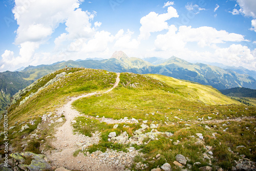 beautiful winding hiking trail with a panorama of the alps in the background