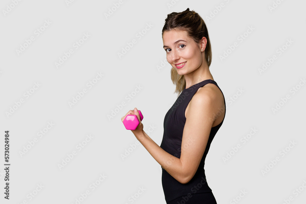 Young female athlete lifting weights, focused and determined in indoor studio Young female athlete lifting weights, focused and determined in indoor studio