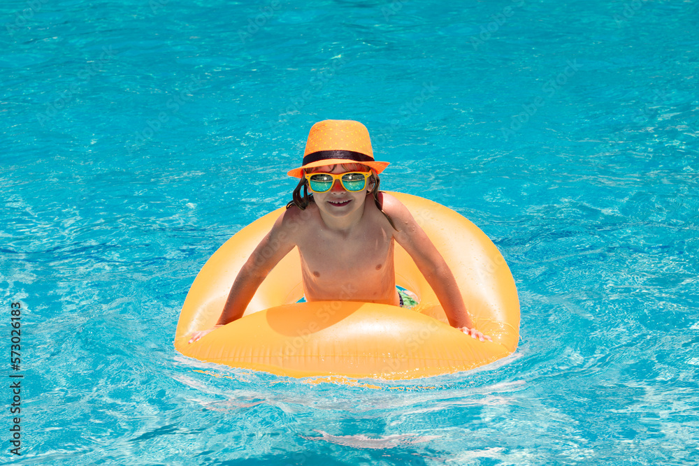 Summer fun kids face. Child boy in swim pool swimming on inflatable ring. Kid swim with orange float. Water toy, healthy outdoor sport activity for children. Kids beach fun. Fashion summer kids hat.