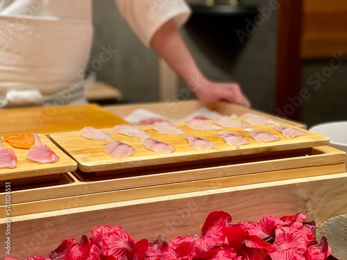 a chef preparing delicious sashimi and nigiri on the table