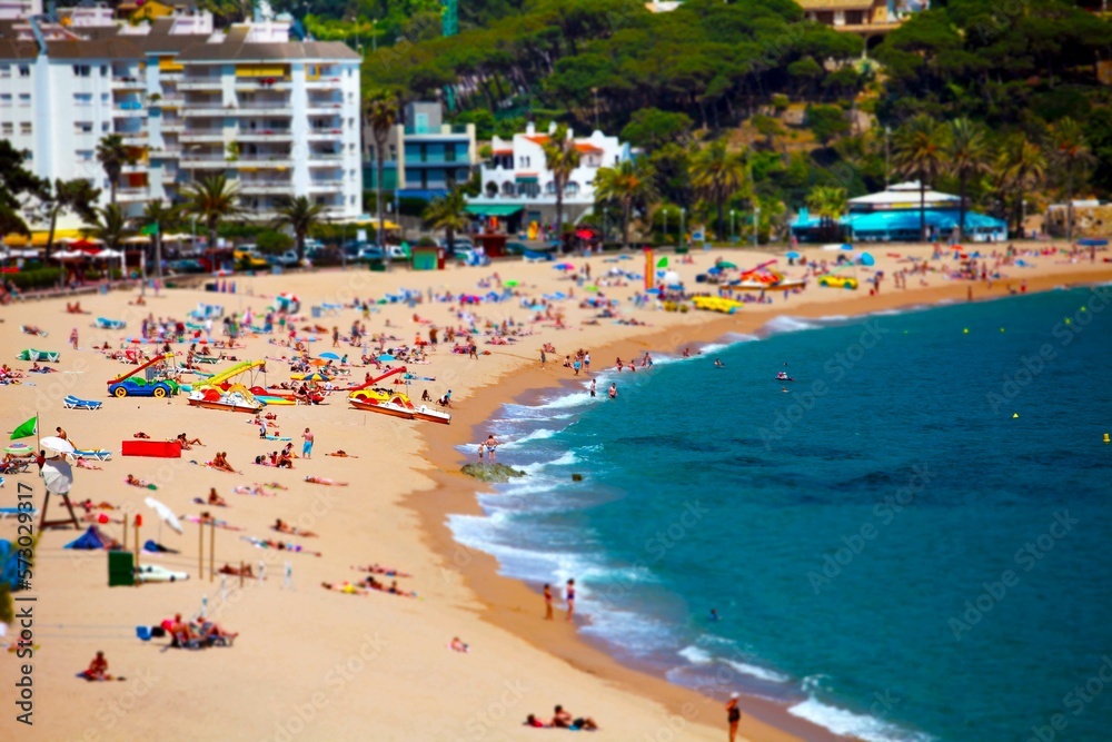 seaside resort, sandy beach, people sunbathing rest tilt shift