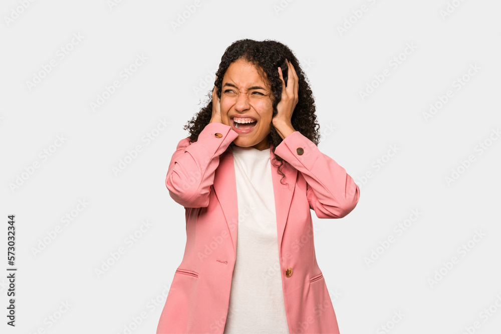 Young african american curly woman isolated covering ears with hands trying not to hear too loud sound. Young african american curly woman isolated covering ears with hands trying not to hear too loud sound.