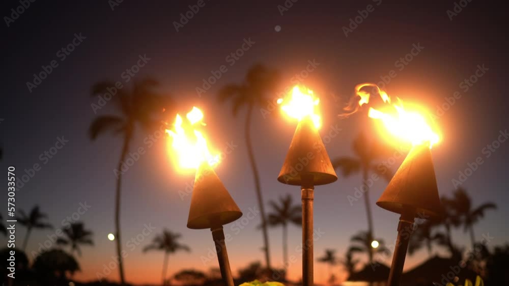 Hawaii sunset with fire torches. Hawaiian icon, lights burning at dusk at resort Hawaii sunset with fire torches. Hawaiian icon, lights burning at dusk at resort