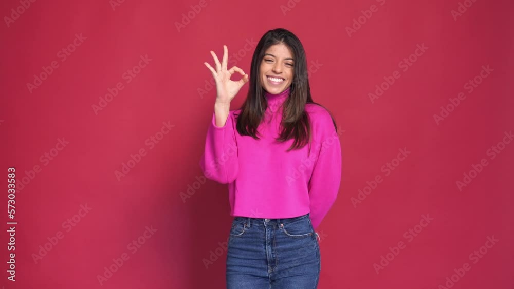 Close up slow motion face of young woman, isolated on red background Close up slow motion face of young woman, isolated on red background