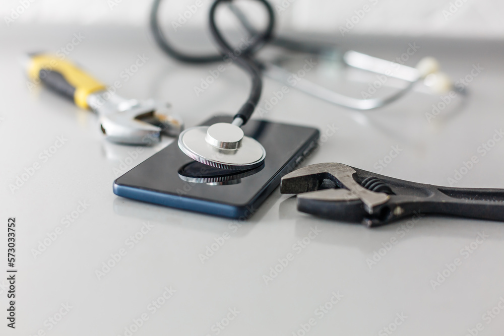 Damaged smartphone and repair tool set on white background, flat lay. Space for text. Damaged smartphone and repair tool set on white background, flat lay. Space for text.
