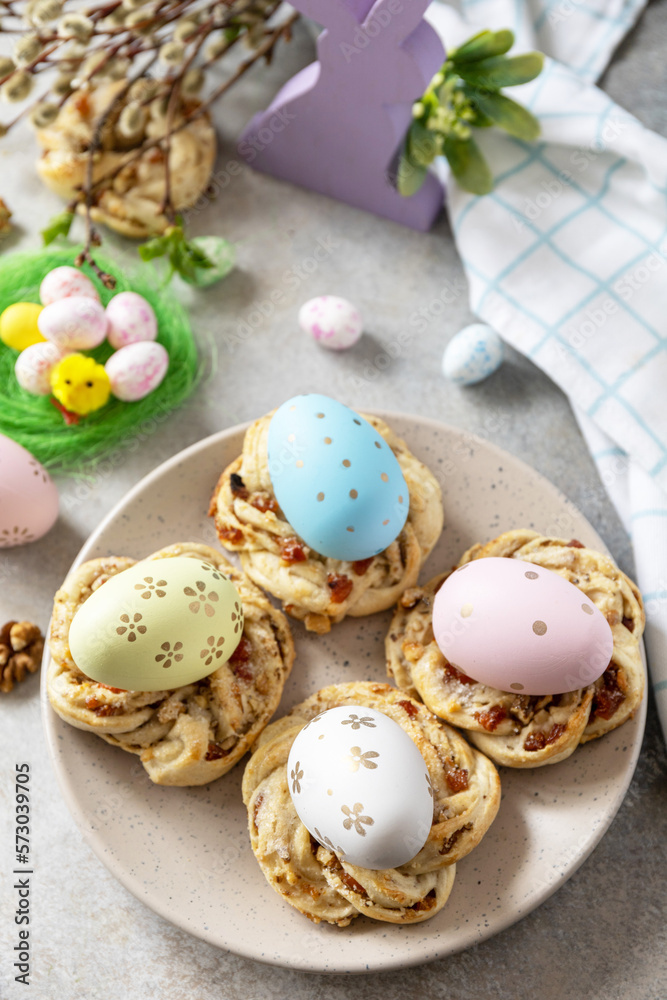Obraz premium Easter composition. Sweet Italian Easter Bread Rings from puff pastry and dyed eggs on a stone background.