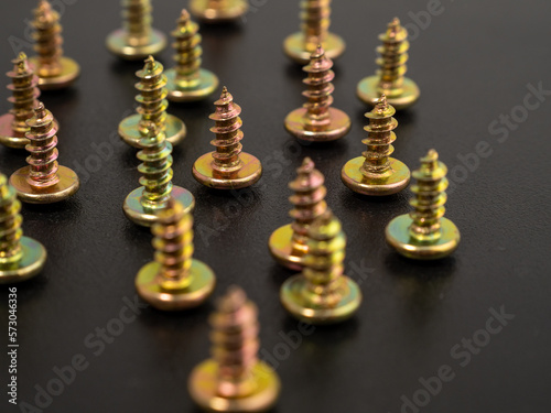 Screws for screwing into plastic. Metal screws on a black background. Close-up.