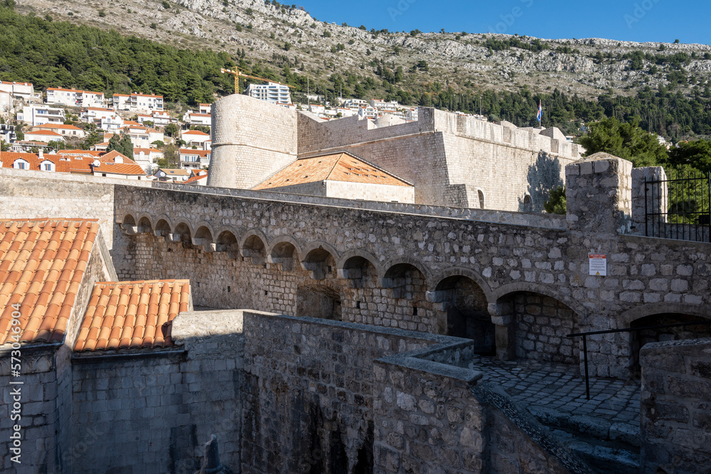 Beautiful Dubrovnik city walk on old, medieval stone walls with view on the city rooftops and famous landmarks