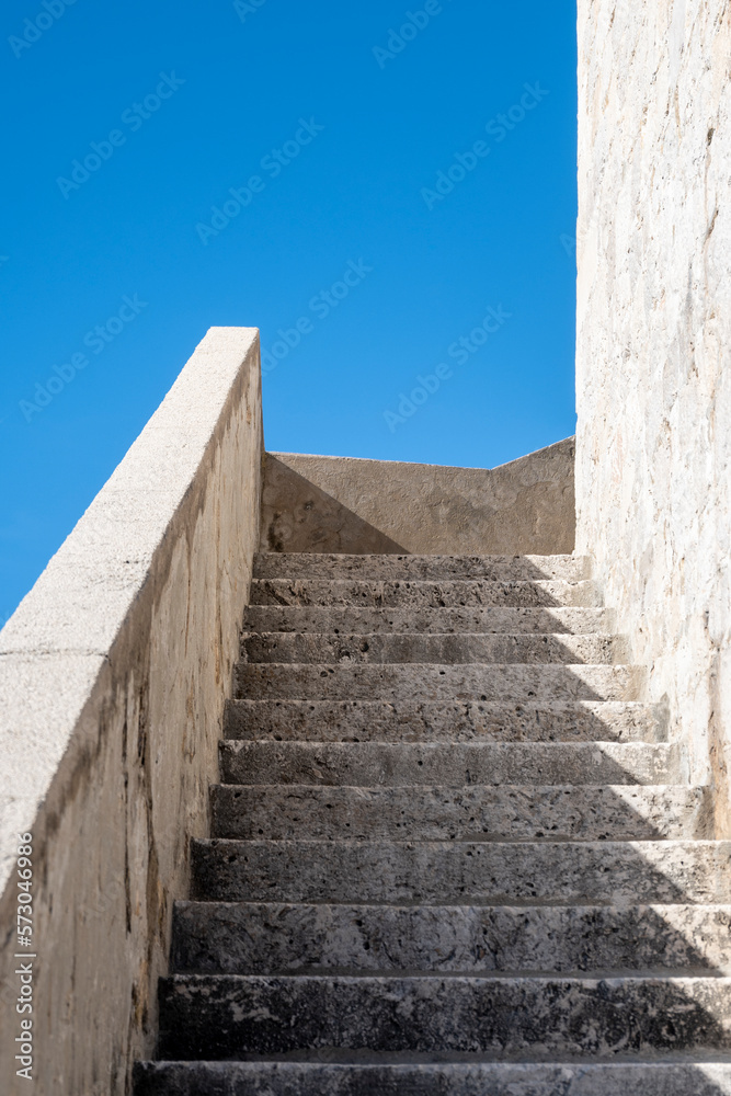 Fototapeta premium Stone stairs on Dubrovnik city walls, Croatia, photographed against clear blue sky, lit by gentle, winter sun