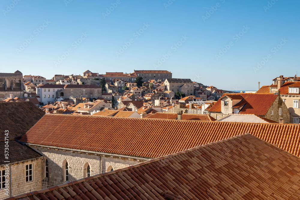 Wonderful Dubrovnik city red rooftops observed from old, stone defence walls that circle the city, now used as tourist attraction to see local landmarks