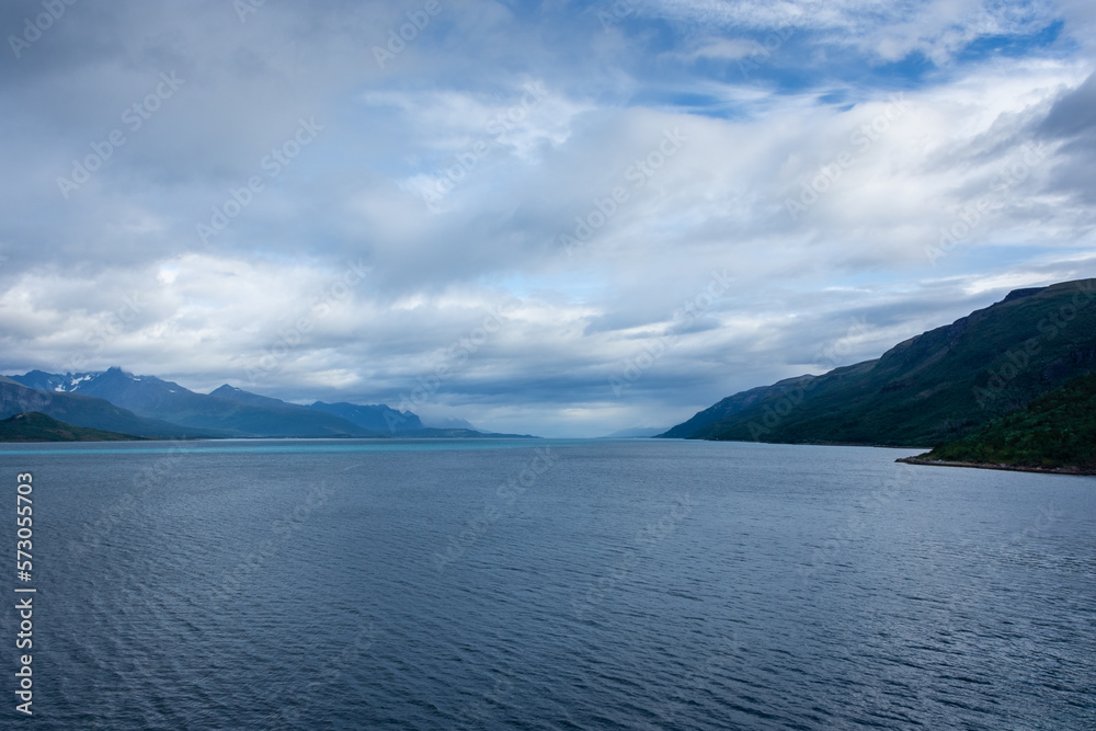 Beautiful  view over a Norwegian fjord from the sea with turquoise water between the mountains
