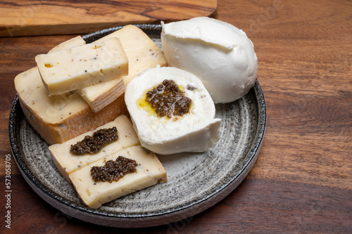 Italian cheese collection, yellow taleggio cheese and mozzarella with black truffles mushrooms