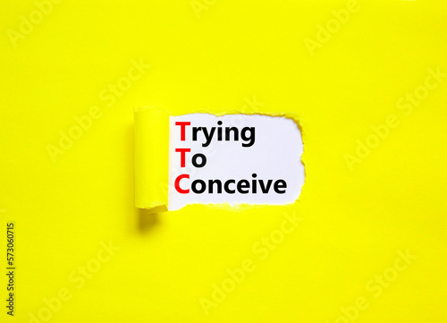 TTC trying to conceive symbol. Concept words TTC trying to conceive on white paper on a beautiful yellow background. Medical and TTC trying to conceive concept. Copy space.