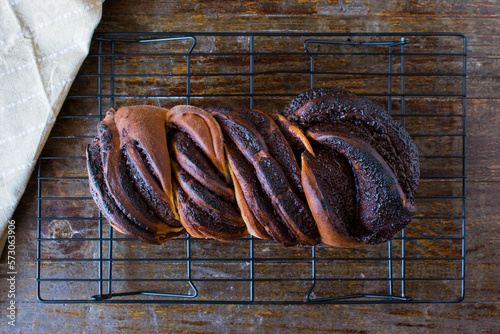 Pan dulce de chocolate trenzado. Bollo de chocolate trenzado (Babka), fondo de madera, vista superior. photo