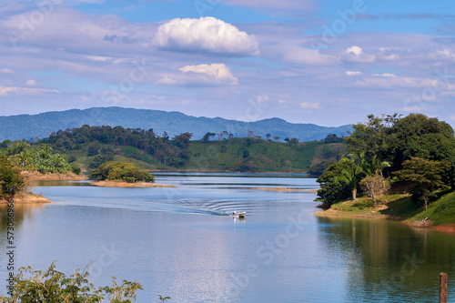 Lancha navegando en la presa Miguel del la Madrid en Temazcal Oaxaca México, embarcación que transporta personas y mercancía entre islas y agua azul con montañas al rededor. 