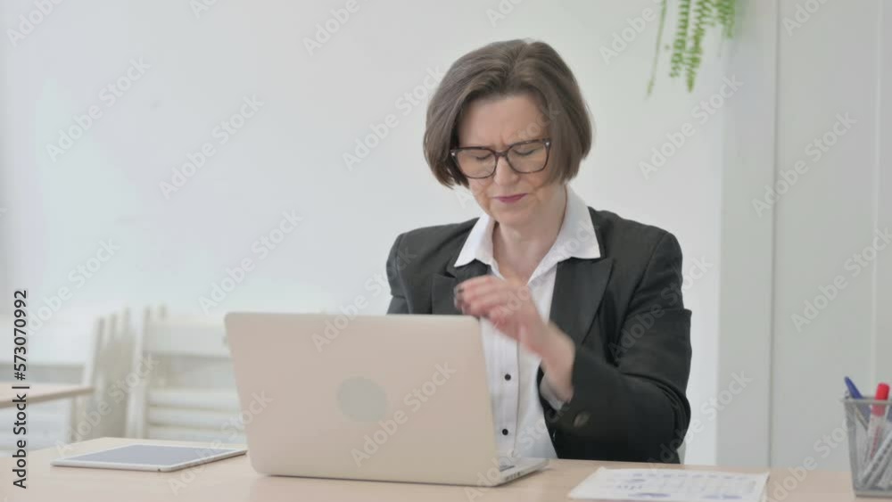 Old Businesswoman Coughing while Working on Laptop Old Businesswoman Coughing while Working on Laptop
