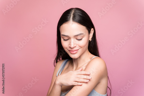 Attractive woman in casual wear touching her arm