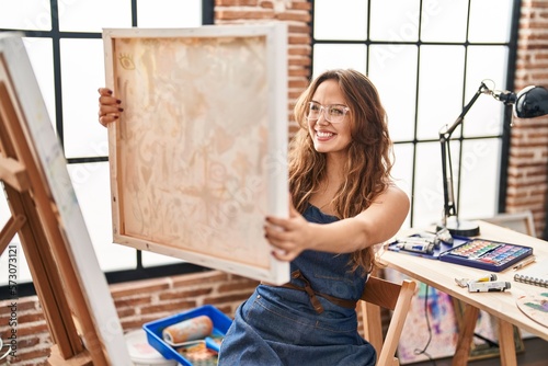 Young beautiful hispanic woman artist smiling confident looking draw at art studio