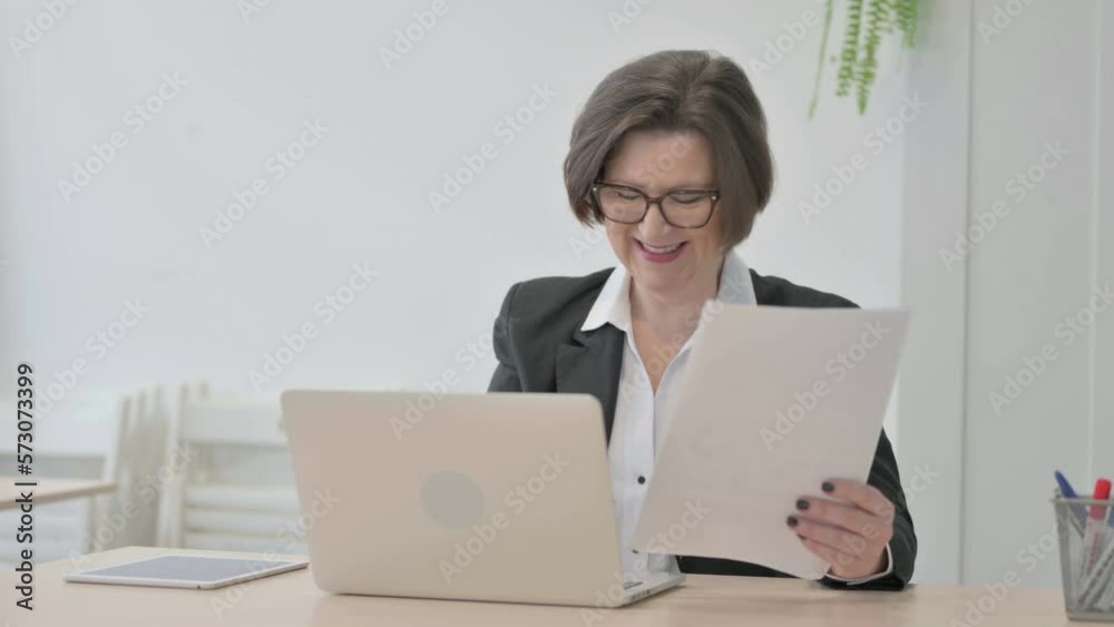 Old Businesswoman Celebrating Success while Doing Paperwork Old Businesswoman Celebrating Success while Doing Paperwork
