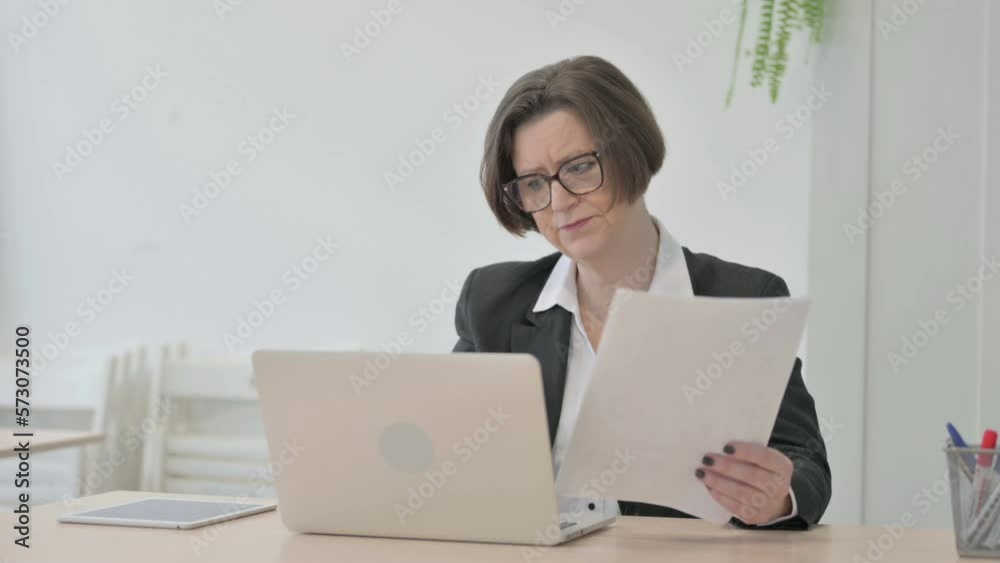 Old Businesswoman Feeling Upset while Doing Paperwork Old Businesswoman Feeling Upset while Doing Paperwork