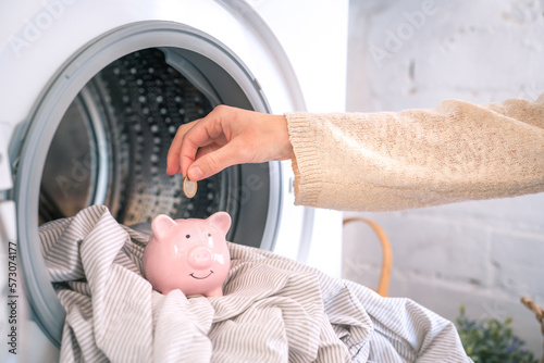 Reduce household bills expenses, money savings piggy bank. Washing machine energy electricity crisis