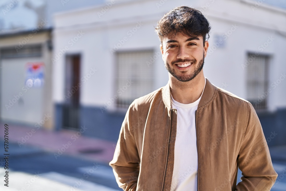 Obraz premium Young hispanic man smiling confident standing at street