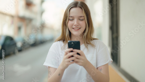 Young caucasian woman smiling confident using smartphone at street