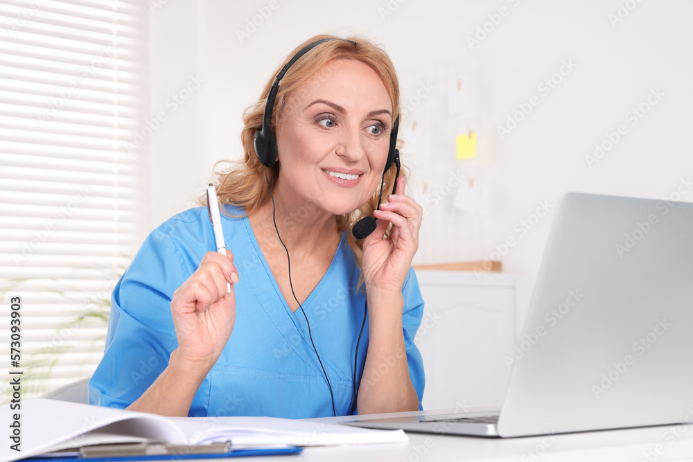 Doctor with laptop and headphones consulting patient in clinic. Online medicine concept Doctor with laptop and headphones consulting patient in clinic. Online medicine concept