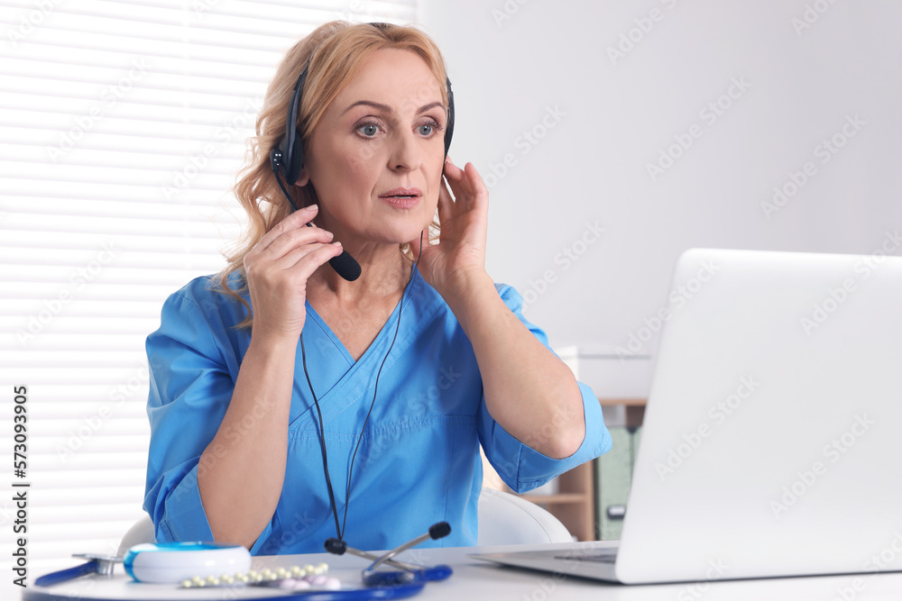 Doctor with laptop and headphones consulting patient in clinic. Online medicine concept Doctor with laptop and headphones consulting patient in clinic. Online medicine concept