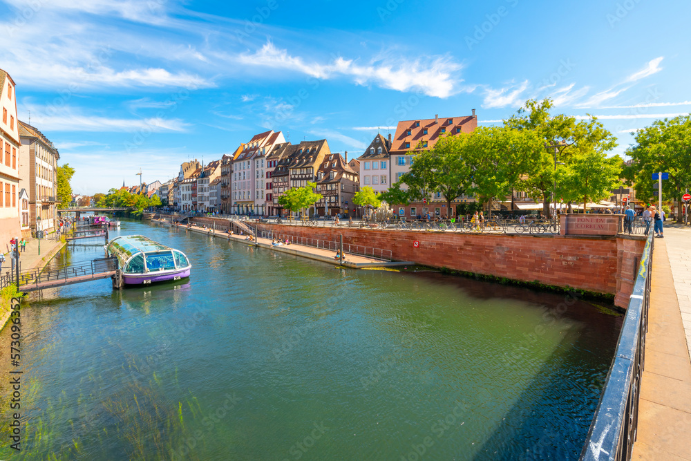 Tourist boats along the riverbank of the Ill River in the historic downtown district of Strasbourg, France.